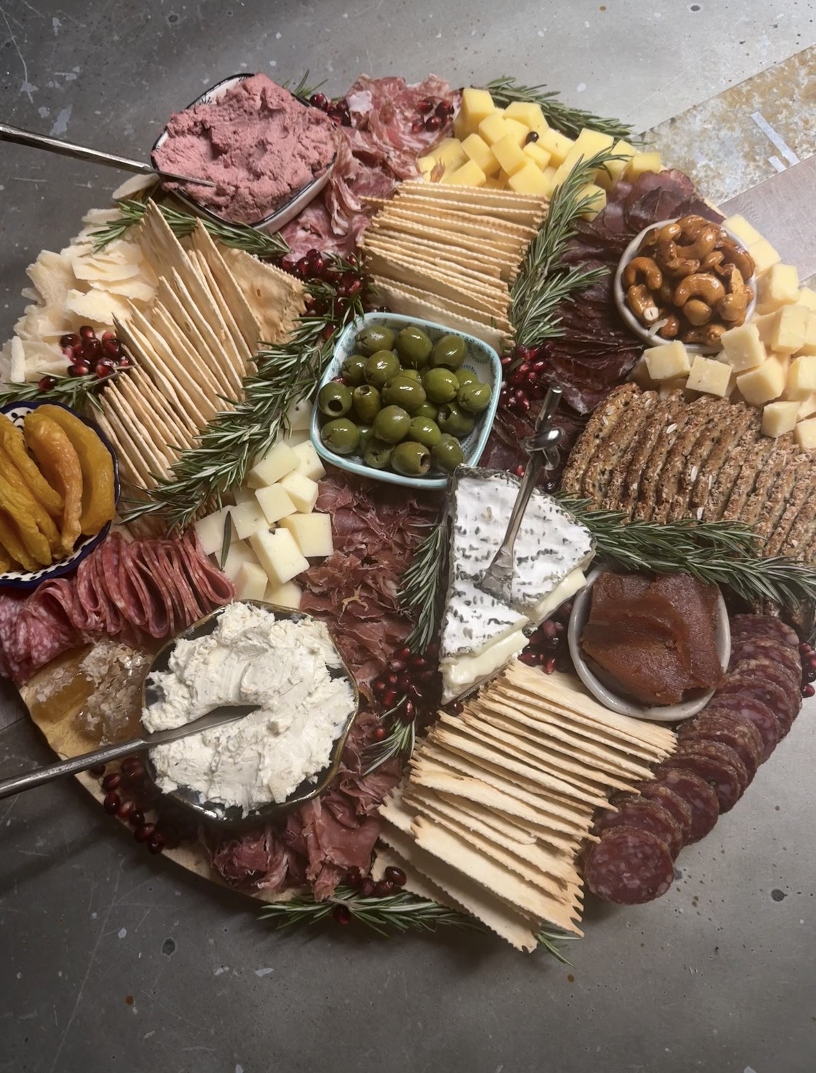 Abundant round luxury charcuterie board with pâté, whipped honey ricotta, blue cheese, prosciutto, olives and rosemary — Fireweed & Fig, Anchorage Alaska