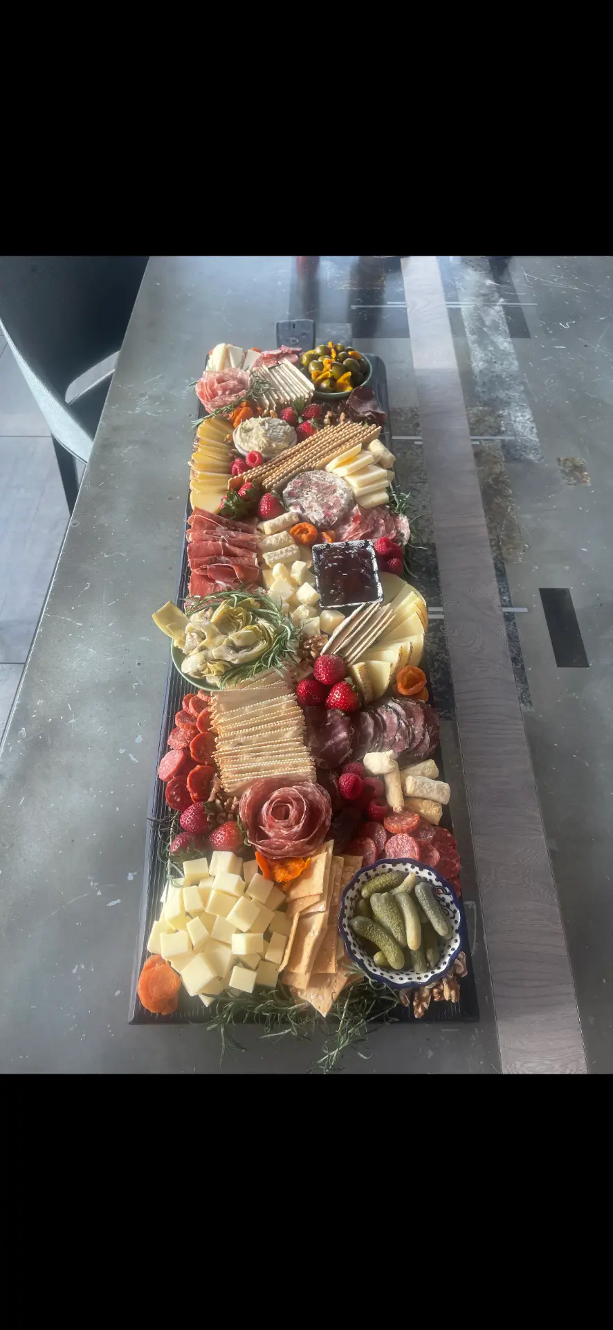 Long styled grazing table for a party with salami, aged cheeses, strawberries and cornichons — grazing table catering Anchorage AK